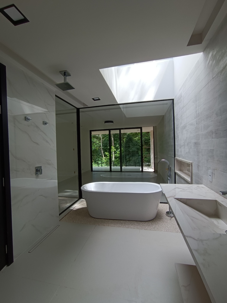 Elegant bathroom featuring a freestanding tub and ample natural light from a large window.